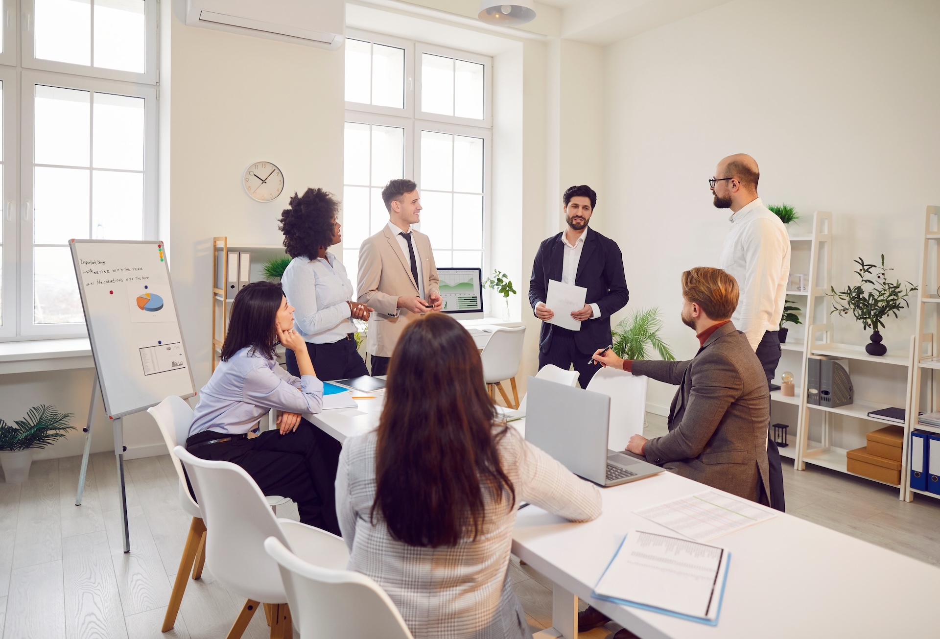The team discusses communication, leadership, and teamwork in a professional office setting, emphasizing collaboration.